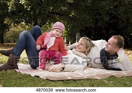 Family with toddler relaxing in park View Large Photo Image Stock Photo - Family with toddler relaxing in park . Fotosearch