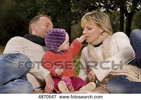 Stock Photo - Family with toddler relaxing in park . Fotosearch