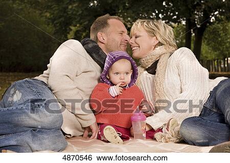 Family with toddler relaxing in park View Large Photo Image Stock Photograph - Family with toddler relaxing in park . Fotosearch