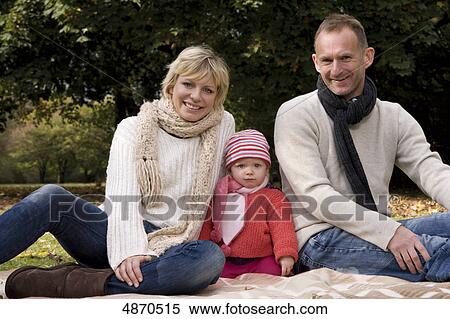 Stock Photography - Family with toddler relaxing in park . Fotosearch