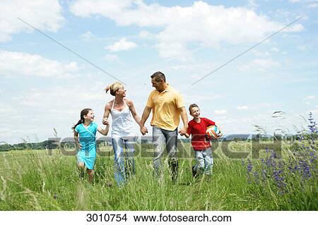 Picture - Family with two children on a meadow, front view . Fotosearch
