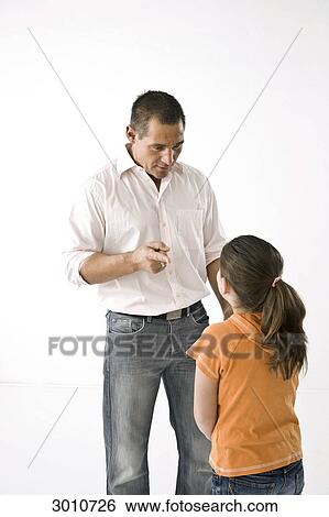 Father advising his daughter, studio shot View Large Photo Image Stock Photograph - Father advising his daughter, studio shot . Fotosearch