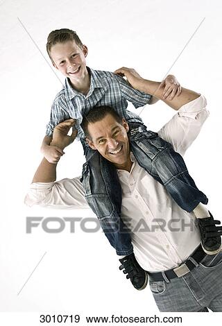 Father carrying son on his shoulders, diagonal, studio shot View Large Photo Image Stock Photo - Father carrying son on his shoulders, diagonal, studio shot . Fotosearch