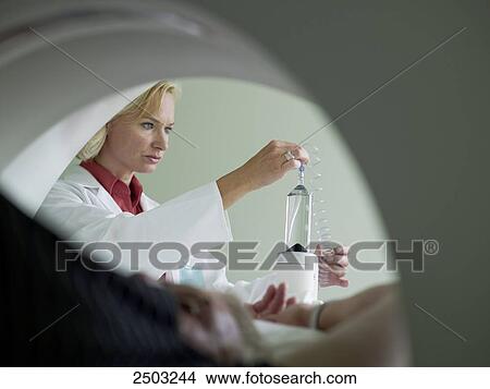Picture - Female doctor adjusting x-ray machine . Fotosearch