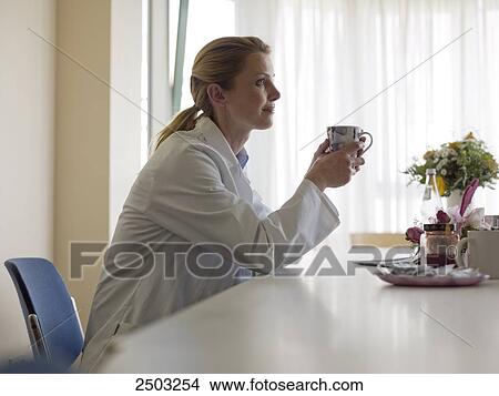Female doctor drinking coffee View Large Photo Image Picture - Female doctor drinking coffee . Fotosearch
