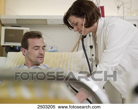 Female doctor examining male patient View Large Photo Image Stock Photography - Female doctor examining male patient . Fotosearch
