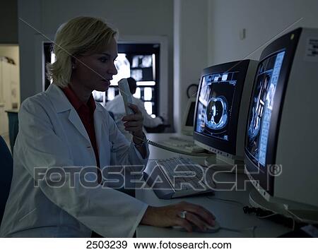 Stock Photo - Female doctor examining medical report on computer . Fotosearch