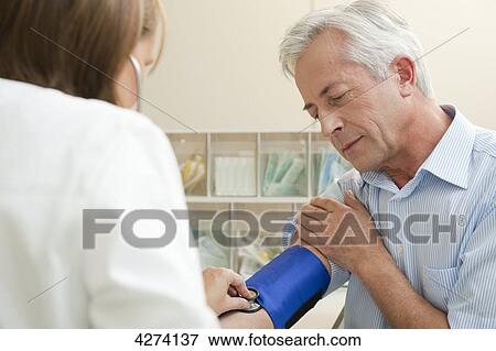 Stock Photo - Female doctor taking patient's blood pressure . Fotosearch