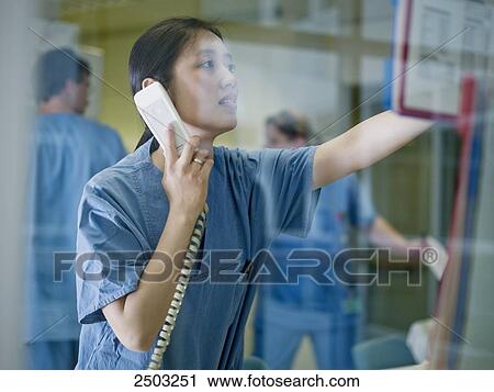 Female doctor talking on landline phone View Large Photo Image Stock Image - Female doctor talking on landline phone . Fotosearch