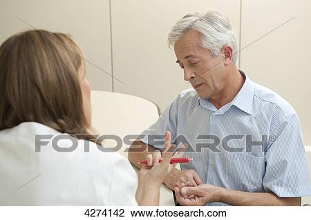Stock Image - Female doctor talking to patient . Fotosearch