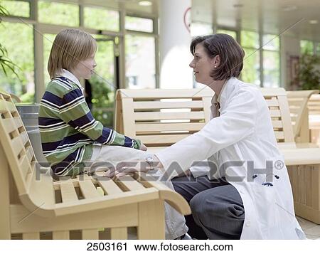 Stock Image - Female doctor talking with patient in waiting room . Fotosearch