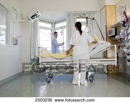 Female nurse changing bed sheet of patient's bed View Large Photo Image Stock Photograph - Female nurse changing bed sheet of patient's bed . Fotosearch