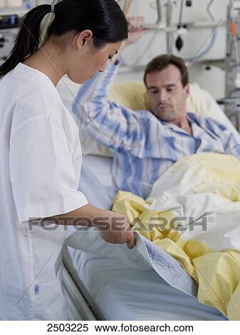 Female nurse changing bed sheet of patient's bed View Large Photo Image Stock Photography - Female nurse changing bed sheet of patient's bed . Fotosearch