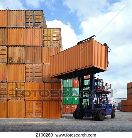 Stock Image - Forklift lifting cargo container at port, Hamburg, Germany . Fotosearch