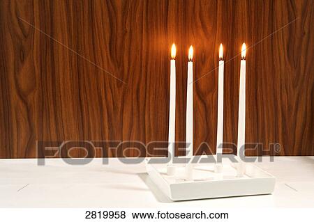 Stock Photo - Four candles burning . Fotosearch