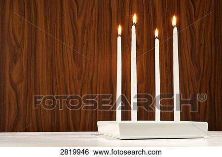 Stock Photograph - Four candles burning . Fotosearch