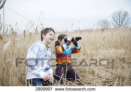 Friends looking through binoculars in forest View Large Photo Image Stock Photo - Friends looking through binoculars in forest . Fotosearch