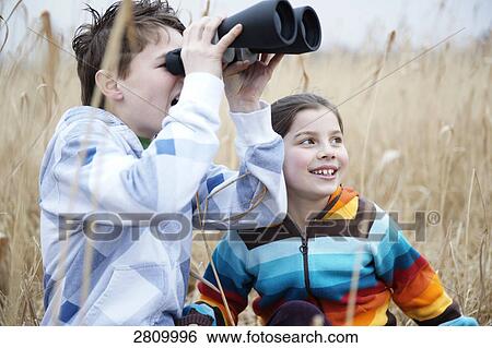 Friends looking through binoculars View Large Photo Image Stock Photograph - Friends looking through binoculars . Fotosearch