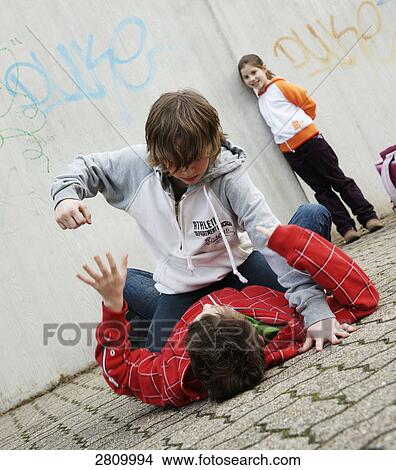 Picture - Friends rough housing in street . Fotosearch