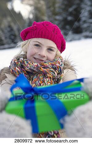 Stock Image - Girl holding gift and smiling . Fotosearch