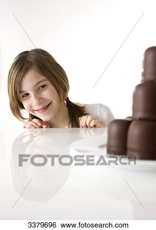 Girl looking at a plate with chocolate marshmallows View Large Photo Image Stock Photograph - Girl looking at a plate with chocolate marshmallows . Fotosearch