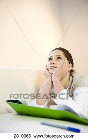Stock Photograph - Girl lying on couch and thinking . Fotosearch