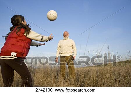 Girl playing volleyball with her grandfather View Large Photo Image Stock Image - Girl playing volleyball with her grandfather . Fotosearch