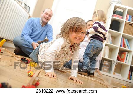 Girl playing with toys and her father playfully pulling her View Large Photo Image Stock Image - Girl playing with toys and her father playfully pulling her . Fotosearch