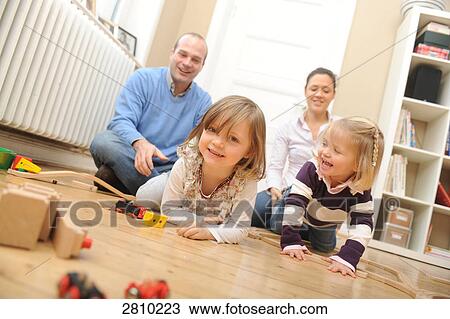 Girl playing with toys and her father playfully pulling her View Large Photo Image Stock Image - Girl playing with toys and her father playfully pulling her . Fotosearch