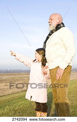 Girl pointing with her grandfather View Large Photo Image Picture - Girl pointing with her grandfather . Fotosearch