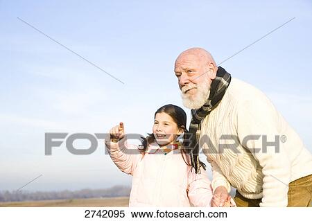 Stock Photography - Girl pointing with her grandfather . Fotosearch