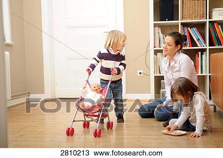Girl pushing doll on baby stroller looking at her mother View Large Photo Image Stock Image - Girl pushing doll on baby stroller looking at her mother . Fotosearch