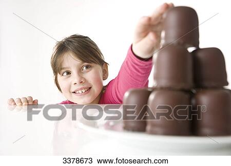Girl reaching for chocolate marshmallows View Large Photo Image Stock Image - Girl reaching for chocolate marshmallows . Fotosearch