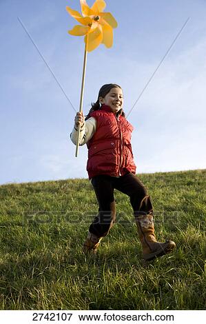 Girl running on landscape with pinwheel View Large Photo Image Stock Photo - Girl running on landscape with pinwheel . Fotosearch