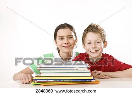 Girl smiling with her brother near books View Large Photo Image Stock Photo - Girl smiling with her brother near books . Fotosearch