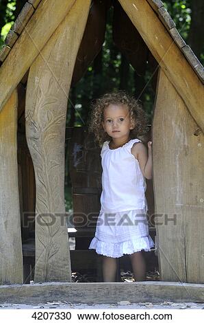 Stock Image - Girl standing in tree house . Fotosearch