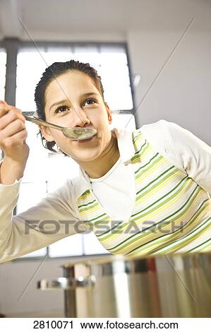 Girl tasting food in kitchen View Large Photo Image Stock Image - Girl tasting food in kitchen . Fotosearch