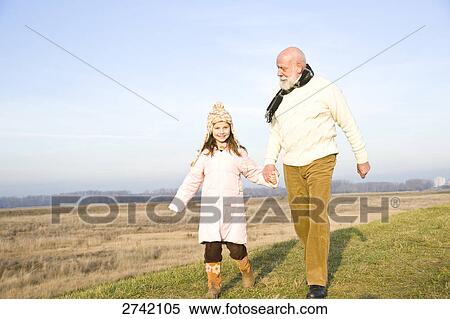 Stock Photography - Girl walking with her grandfather . Fotosearch