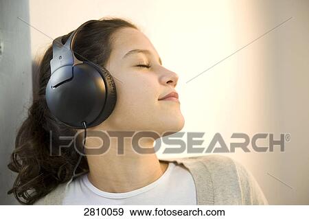 Girl wearing headphones and listening to music View Large Photo Image Stock Photo - Girl wearing headphones and listening to music . Fotosearch