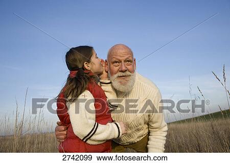 Girl whispering to her grandfather View Large Photo Image Stock Photo - Girl whispering to her grandfather . Fotosearch