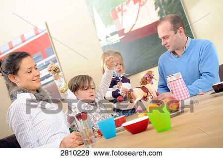 Girl with her parents at dining table View Large Photo Image Stock Photo - Girl with her parents at dining table . Fotosearch