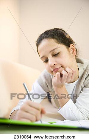 Picture - Girl writing on sheet of paper . Fotosearch