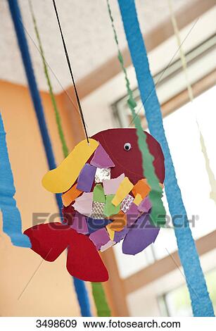 Stock Photo - Handmade fish hanging from the ceiling of a kindergarten, low angle view . Fotosearch