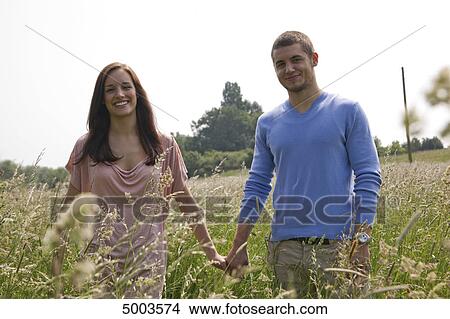 Picture - Happy young couple in field . Fotosearch