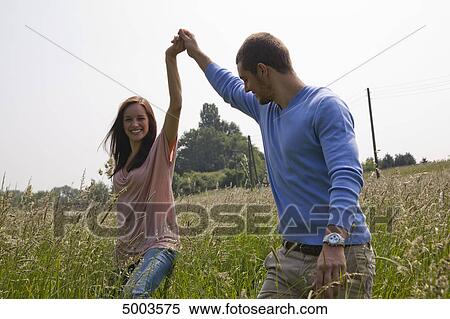 Stock Photography - Happy young couple in field . Fotosearch