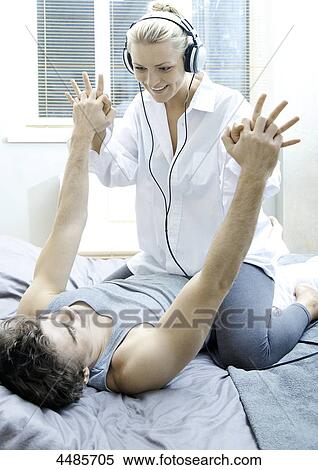 Stock Photography - Happy young couple on bed . Fotosearch