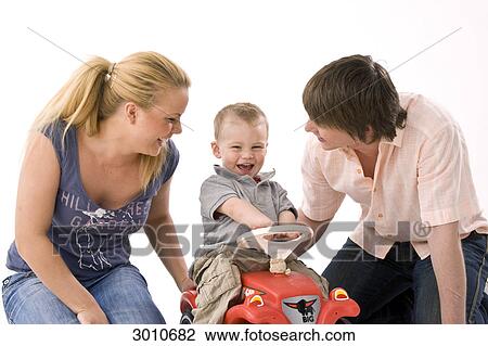 Stock Image - Happy young couple with child, studio shot . Fotosearch