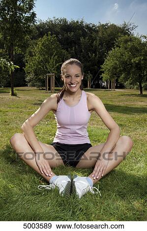 Stock Photo - Happy young woman in sportswear on meadow . Fotosearch