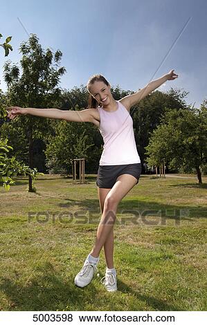 Happy young woman in sportswear on meadow View Large Photo Image Stock Photo - Happy young woman in sportswear on meadow . Fotosearch