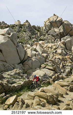 Stock Photo - High angle view of man cycling at coast . Fotosearch